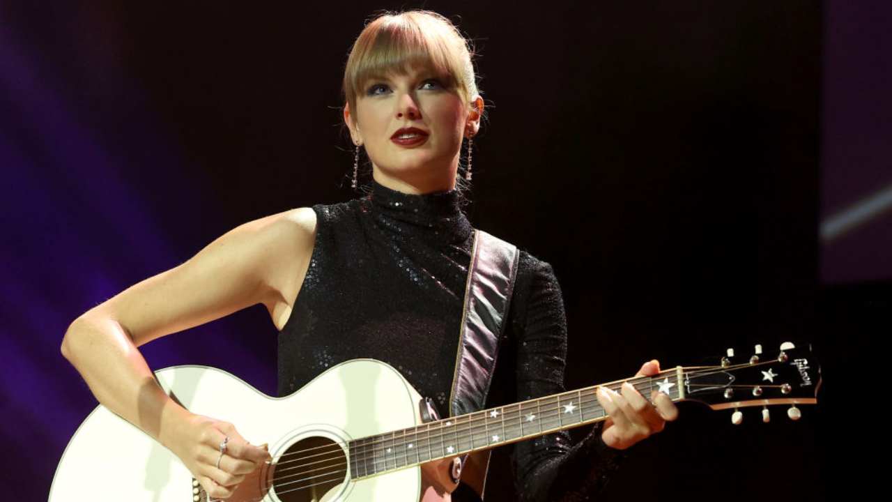 Taylor swift cantando con una guitarra